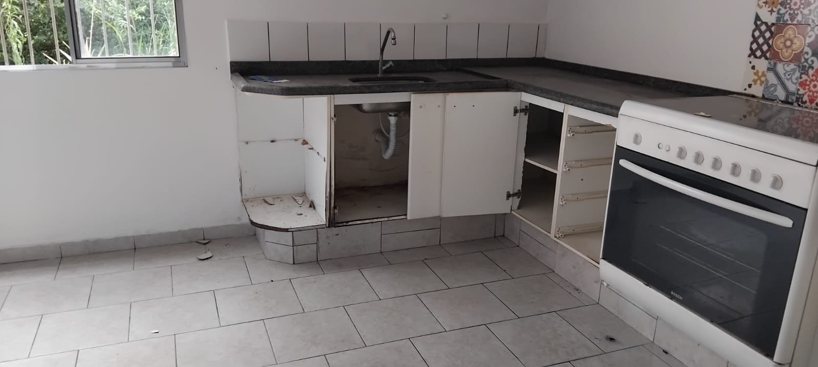 Cozinha planejada com portas e painéis avariados antes da reforma